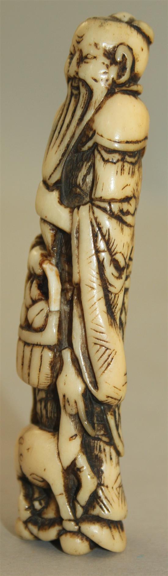 A Japanese stag antler netsuke of a standing sennin, Edo period, 9.8cm